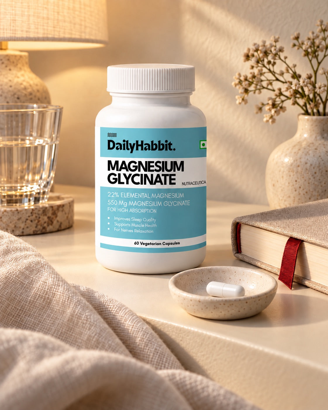 DailyHabbit Magnesium Glycinate bottle with a single white capsule, linen and a book in an evening still life.